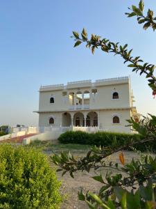 a large white building on the beach at Dera Padlia - A Rural Experience Farm Stay 