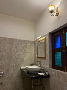 a bathroom with a sink and a window at Dera Padlia - A Rural Experience Farm Stay 