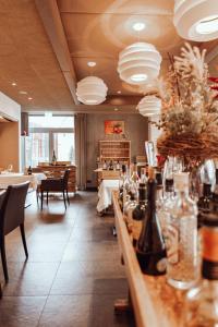 バーリンゲンにあるEncanto Hotel Restaurantのテーブルと椅子のあるレストラン、ボトル入りバー