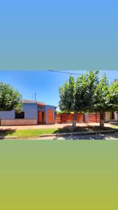 un bâtiment avec deux arbres devant lui dans l'établissement Los Velitos, à Santa Rosa del Conlara