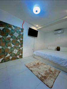 a bedroom with a bed and a tv and a rug at Aloha Cabana Resort And Events in Surigao