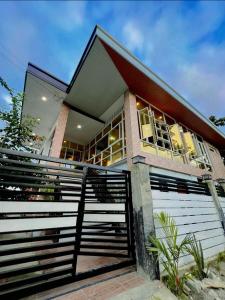 een huis met een hek ervoor bij Aloha Cabana Resort And Events in Surigao