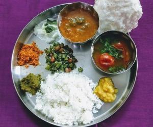 11 Gaon Mudhouse Homestay في لانسداون: طبق من الطعام مع الرز وأنواع مختلفة من الطعام
