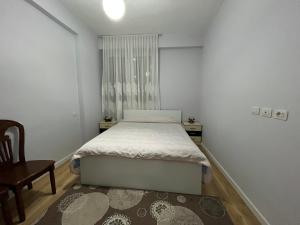 - une chambre avec un lit, une chaise et une fenêtre dans l'établissement SALA Apartment, à Shkodër