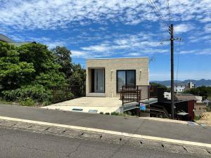 a small house sitting on the side of a street at Shirahama Yamate Rent Villa A-2-3 in Shirahama