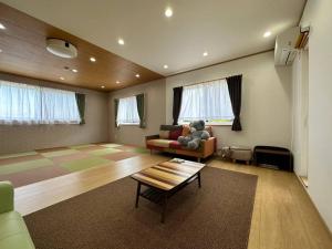 Shirahama Yamate Rent Villa A-2-3 في شيراهاما: غرفة معيشة مع أريكة وطاولة قهوة