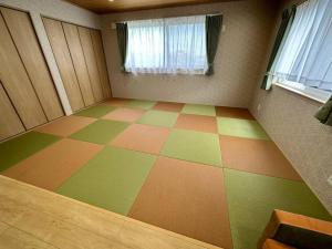 Shirahama Yamate Rent Villa A-2-3 في شيراهاما: غرفة مع أرضية متقاطعة مع نافذة