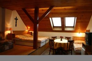 インドルジフーフ・フラデツにあるPenzion Kapitanのベッド2台、テーブル、椅子が備わる客室です。