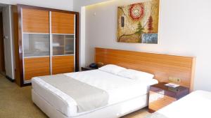 una camera con letto bianco e testiera in legno di Hotel La Bella Salihli a Salihli