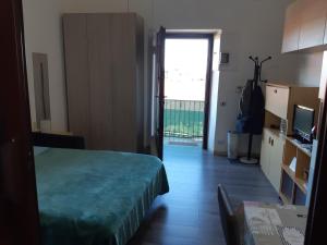 1 dormitorio con 1 cama y puerta a un balcón en Affittibreviferrera monolocale Ferrera 20 minuti da RHO Fiera, en Bareggio