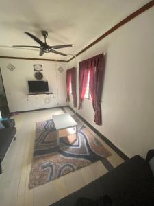 een woonkamer met een tafel en een tapijt bij Chu Mon's Homestay Janda Baik (15 min from river) in Bentong