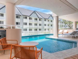 an image of a swimming pool at a hotel at Hemingway Palm Beach - Premium Oceanview Apartments in Gold Coast