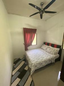 1 dormitorio con 1 cama y ventilador de techo en Chu Mon's Homestay Janda Baik (15 min from river) en Bentong