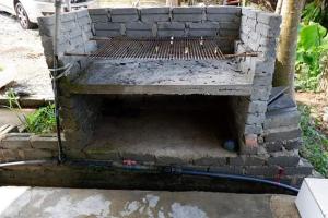 a brick oven with a hose coming out of it at Chu Mon's Homestay Janda Baik (15 min from river) in Bentong