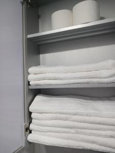 un armario con toallas blancas en un estante en Elle House, en Jeonju