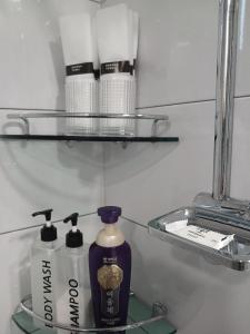 estante con una botella de jabón y artículos de aseo en Elle House, en Jeonju