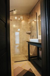 La salle de bains est pourvue d'une douche et d'un lavabo blanc. dans l'établissement Bereg holiday park, à Svetlogorskoye