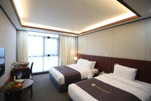 um quarto de hotel com duas camas e uma janela em Benikea hotel seosan em Seosan