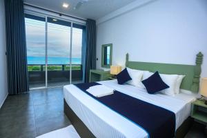 a bedroom with a large bed with a view of the ocean at Villa beachcomber in Ambalangoda