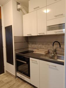 a kitchen with white cabinets and a sink at Studio Lara in Zagreb