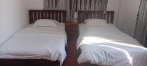 dwa łóżka siedzące obok siebie w sypialni w obiekcie 阳光客栈 w mieście Luang Prabang