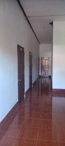 an empty room with two doors and a tile floor at 阳光客栈 in Luang Prabang