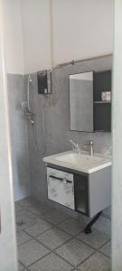 La salle de bains est pourvue d'un lavabo et d'un miroir. dans l'établissement 阳光客栈, à Luang Prabang