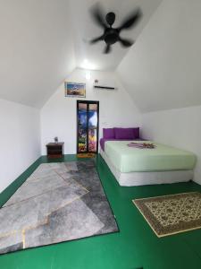 Schlafzimmer mit einem Bett und einem Deckenventilator in der Unterkunft DEWATI ROOMSTAY B&B in Lang Tengah