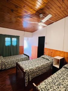 Santa Rosa del Conlara的住宿－Los Velitos，客房设有三张床和木制天花板。