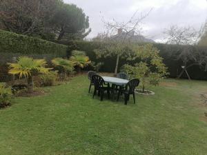 een tafel en stoelen in het gras bij KAZE Maison chaleureuse Evreux, quartier résidentiel Saint Michel in Évreux