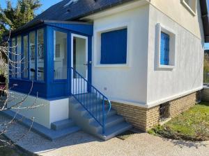 une petite maison avec une porte bleue et des escaliers dans l'établissement KAZE Maison chaleureuse Evreux, quartier résidentiel Saint Michel, à Évreux