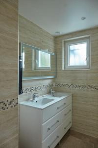uma casa de banho com um lavatório branco e um espelho. em KAZE Maison chaleureuse Evreux, quartier résidentiel Saint Michel em Évreux