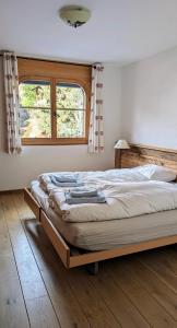 a large bed in a bedroom with a window at Alpenpanorama Ovronnaz in Ovronnaz