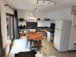 uma cozinha com uma mesa e um frigorífico branco em A découvrir Superbe Maison Calme et Lumineuse em Vallouise