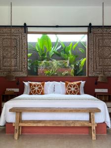 a bedroom with a large bed and a window at Lasai Villas in Gili Air