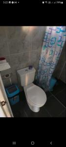 a bathroom with a toilet and a shower curtain at QuiapoSuites Bohol in Tagbilaran City