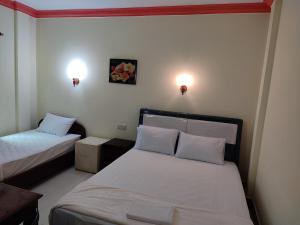 a bedroom with two beds and two lights on the wall at GALAXY Rs HOTEL in Phnom Penh