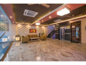 eine Lobby mit einem Wartezimmer mit Sofa und Treppe in der Unterkunft Kusum House in Greater Noida