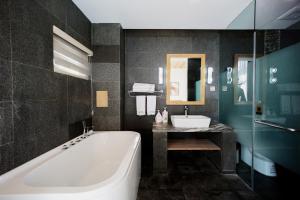 La salle de bains est pourvue d'une baignoire et d'un lavabo. dans l'établissement Dali Ink Inn, à Dali