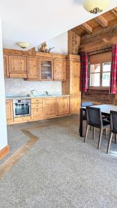 uma cozinha com armários de madeira e uma mesa com cadeiras em Alpenpanorama Ovronnaz em Ovronnaz