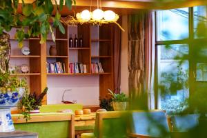 - un salon avec un canapé vert et une étagère dans l'établissement Dali Ink Inn, à Dali
