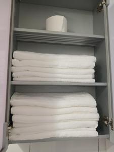un placard rempli de serviettes blanches sur une étagère dans l'établissement Elle House 2, à Jeonju