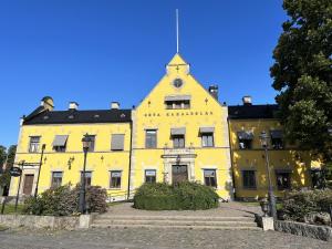 a yellow building with a clock on the top of it at Nice apartment in Motala in Motala