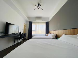 Habitación de hotel con 2 camas y escritorio en Kimen Yuyu B&B, en Jinning