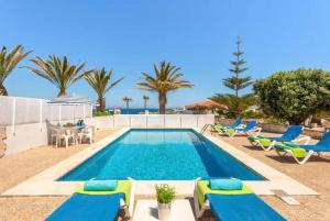 una piscina con tumbonas y una piscina en Villa Mar Azul en Arenal d'en Castell