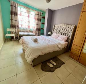 a bedroom with a bed and a pair of shoes on the floor at Eclectic 2 bedrm homely & comfy in Machakos