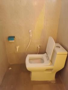 La salle de bains est pourvue de toilettes et d'un téléphone mural. dans l'établissement 11 Gaon Mudhouse Homestay, à Lansdowne