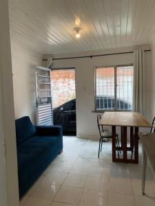 a living room with a blue couch and a table at Casa simples in Belém