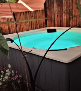 a hot tub in a backyard with a fence at Windsong Living The Nest in Krugersdorp
