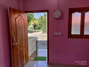 a pink room with a door and a window at Harmony Waves Homestay in Havelock Island